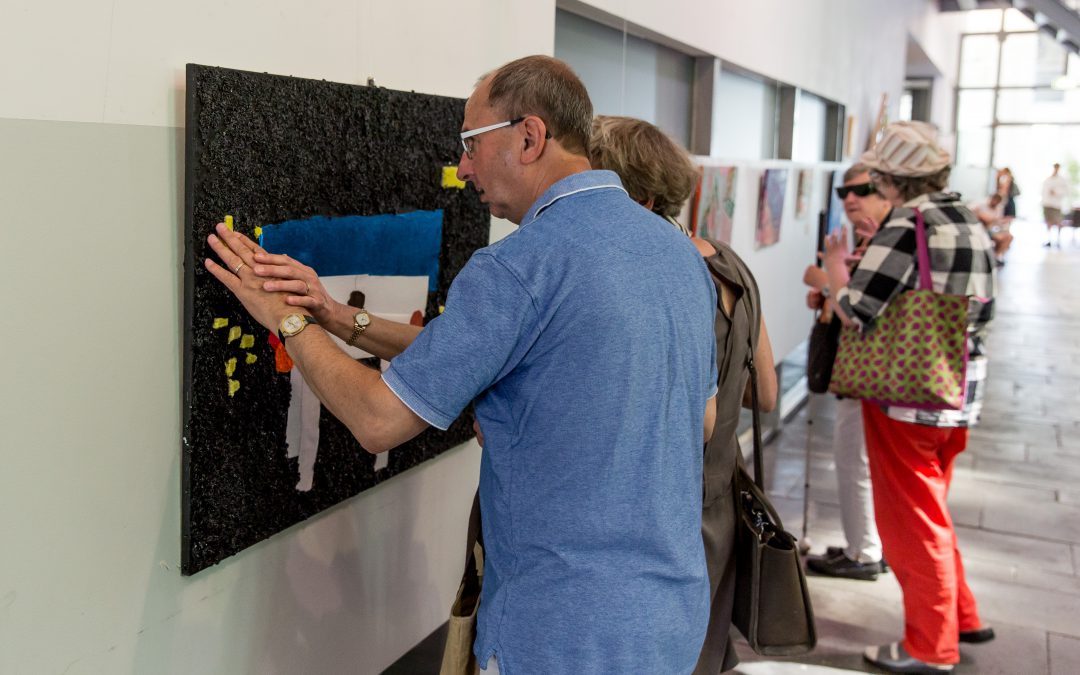 Bezoekers expositie bekijken het schilderij Tafelgesprek van Corrie Balemans